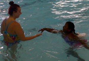 A Great South Bay YMCA swimming instructor teaches a child how to swim on Tuesday, June 18, 2013.