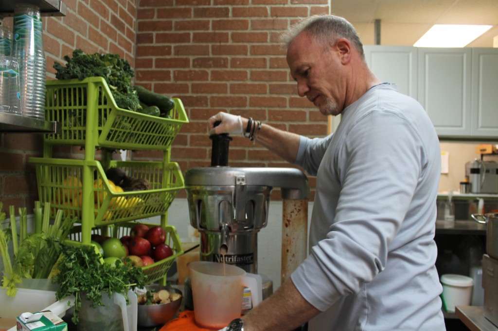 Chris Margulies, owner of Massapequa’s Organic Corner, making an organic pressed juice called “Essential Red.” 