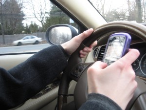 A driver uses their cell phone while behind the wheel.