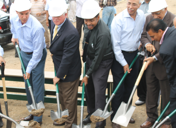 ICLI members and local officials celebrate groundbreaking by digging shovels into the ground.
