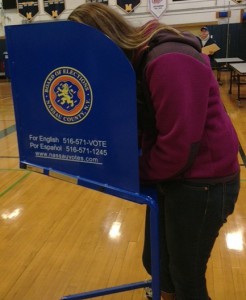 A voter casts her ballot at Massapequa High School.