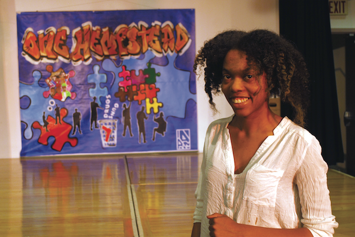 Fatimah White, the museum’s multi-talented art educator, shows off the mural created at one of her workshops by students of the H.Y.P.E. Academy in Hempstead. (Spencer Rumsey/Long Island Press)