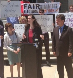 Lisa Tyson, executive director of the Long Island Progressive Coalition, speaks at a rally outside the Theodore Roosevelt Executive & Legislative Building.