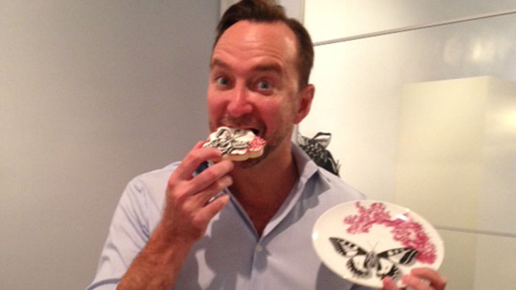 Clinton Kelly happily devours a gourmet cookie fashioned in the shape of his new Effortless Table dinnerware, compliments of uber-fan Lauren Dillon of Rancho Laurena Edible Arts. (Jaime Franchi/Long Island Press)