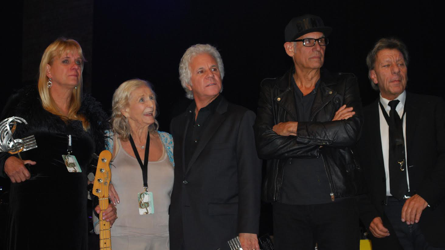 Family members of late Billy Joel Band bassist Doug Stegmeyer (holding his bass) stand alongside BJB guitarist Russell Javors, drummer Liberty DeVitto and saxophonist Richie Cannata onstage at The Paramount in Huntington Thursday, Oct. 23, 2014 at the group's induction into the Long Island Music Hall of Fame. (Christopher Twarowski / Long Island Press)