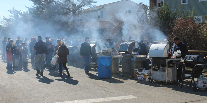 Volunteers grilled hotdogs and hamburgers donated by Ray “The Plumber,” serving hot food to hundreds of hungry residents still suffering from Hurricane Sandy’s wrath. (Christopher Twarowski/Long Island Press)