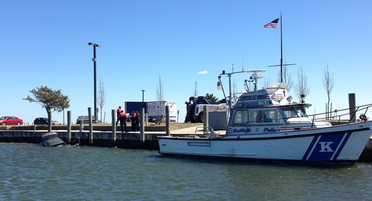 Suffolk police Marine Bureau officers respond to submerged car at Bay Shore Marina. (Credit: SCPD)