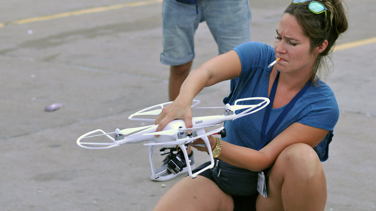 A journalist prepares to use a drone to film a news story from the air.