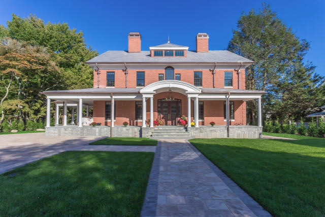 Front brick exterior with wrap around slate porch and roof and copper gutters.