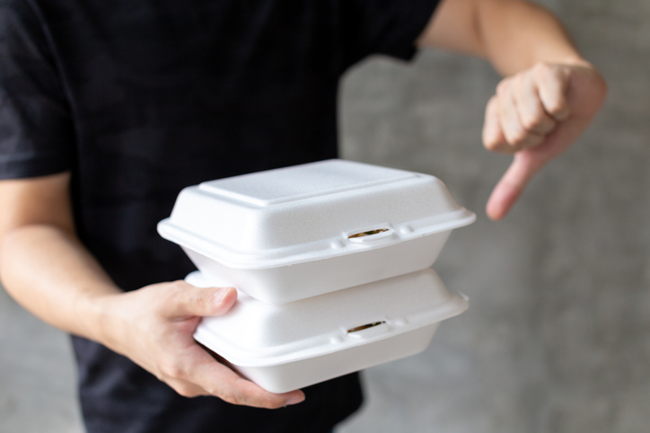 Man holding foam boxes and showing thumb down