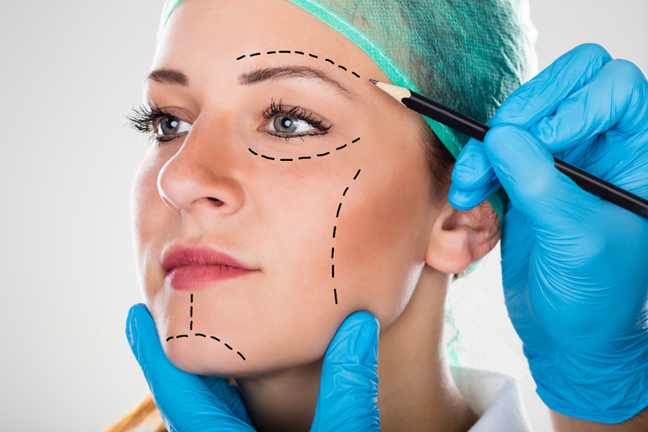 Surgeon Drawing Perforation Lines On Woman’s Face