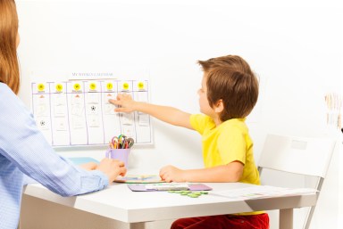 Boy points at activities on calendar learning days