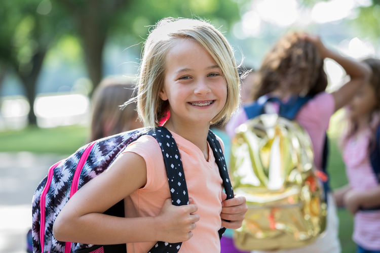 Smiling blonde little girl ready for school