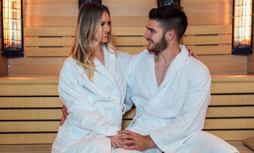 Healthy beautiful couple relaxing in sauna during wellness weekend