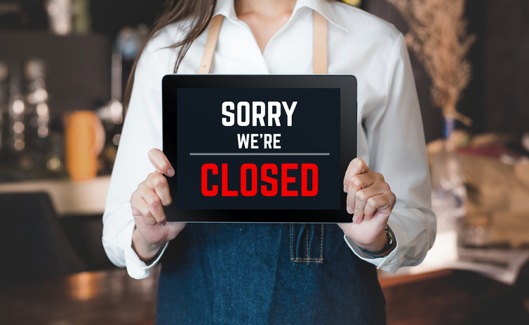 asian barista shop owner holding tablet sign sorry we’re closed in front of counter bar. bankrupt business when coronavirus(covid-19) is outbreak in city