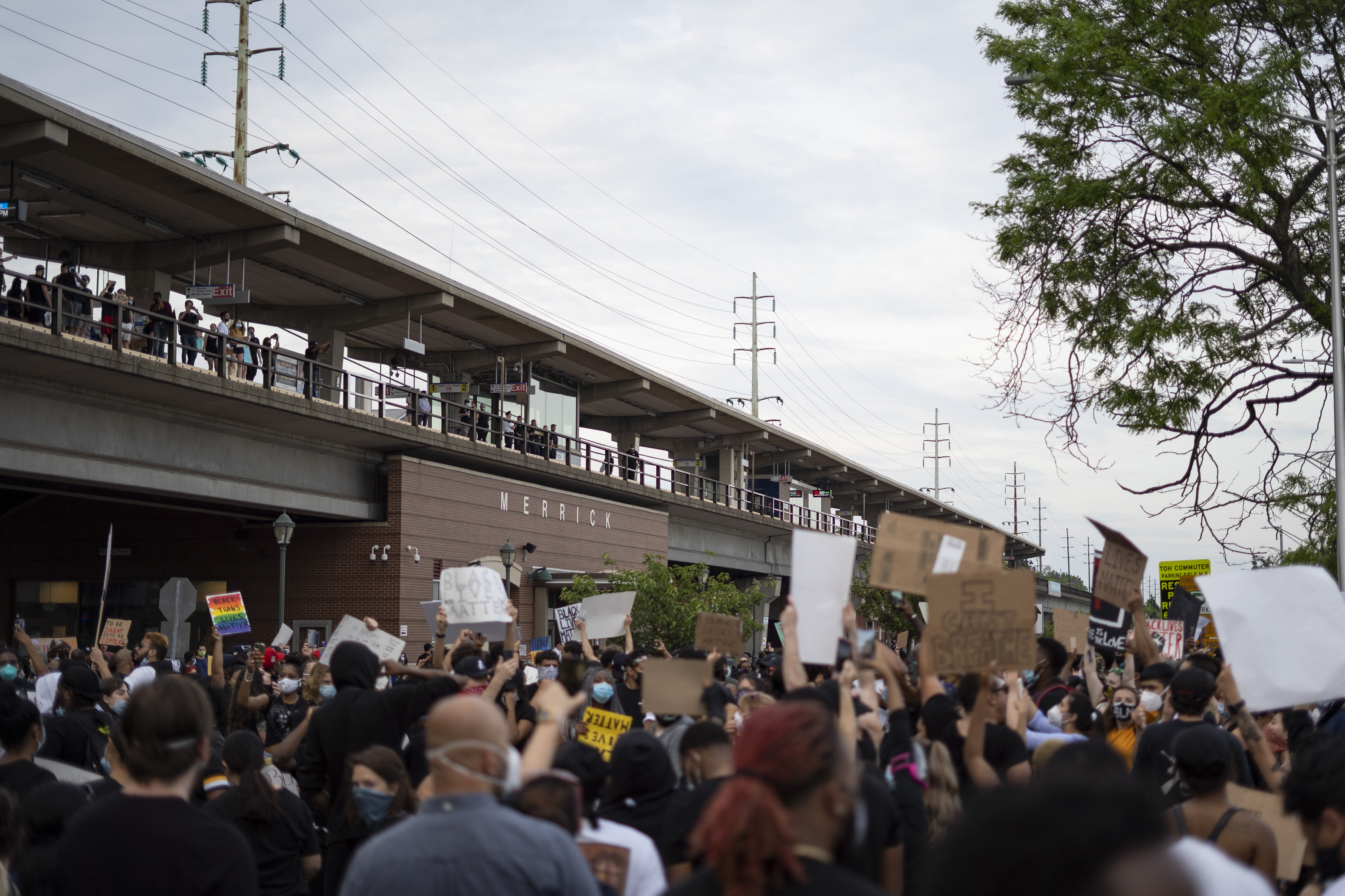 Protestors briefly gathered outside of Merrick train station after walking to Bellmore and before heading north