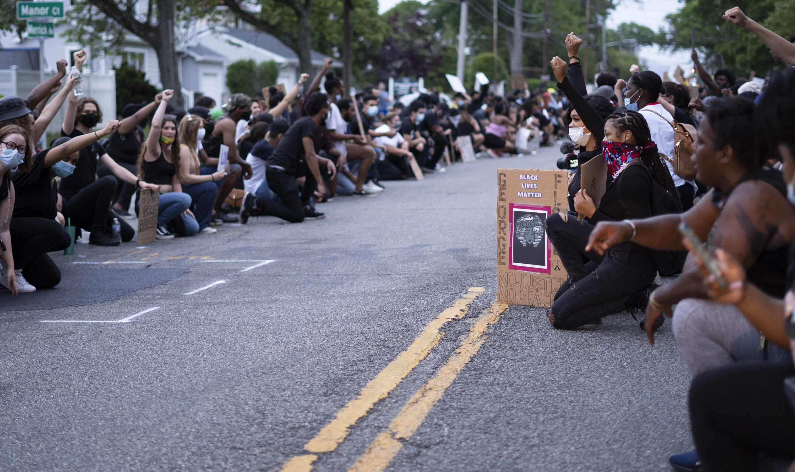 Protestors kneeling on Merrick Ave
