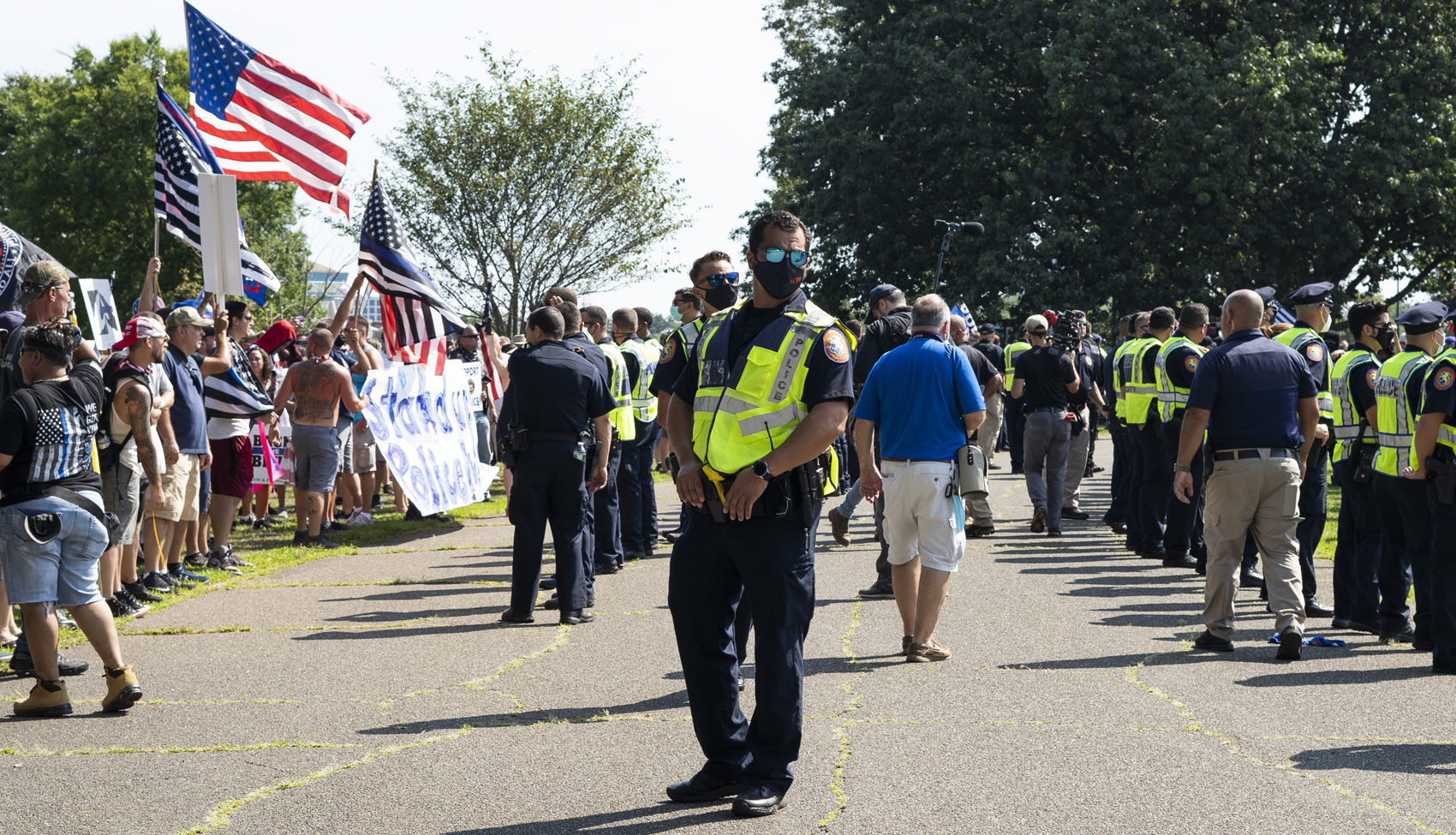 Police seperate a crowd of rally attendees and counter protestors e1595767137828