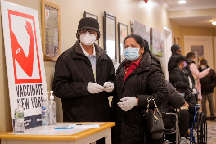 FILE PHOTO: People wait in line to receive Pfizer's coronavirus disease (COVID-19) vaccine at a pop-up community vaccination center at the Gateway World Christian Center in Valley Stream, New York coronavirus