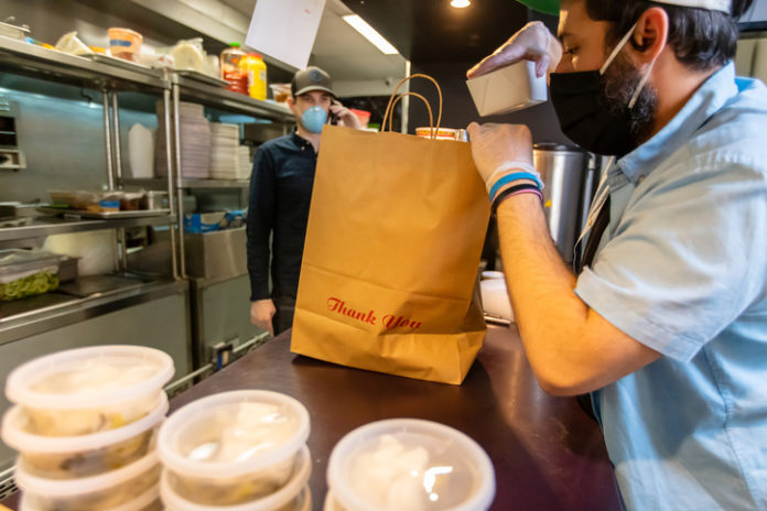 Owners of Local Restaurant Taking Orders on the Phone and Boxing Food for Delivery During Covid-19 Pandemic local restaurants