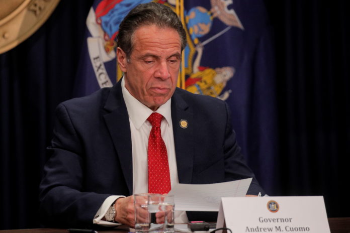New York Governor Andrew Cuomo reads a note during a news conference at his offices in New York covid-19 tests