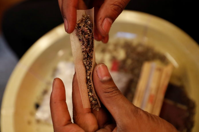 A man rolls a hybrid strain joint of cannabis to smoke at his home in New York pot legalization