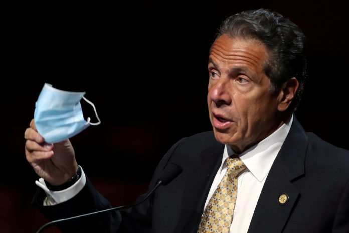 FILE PHOTO: New York Governor Andrew Cuomo speaks at news conference from the stage at Radio City Music Hall in New York pandemic book