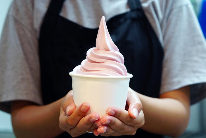 Closeup of woman ‘s hand holding takeaway cup with organic frozen yogurt ice cream, It’s delicious and healthy enjoy eating concept.
