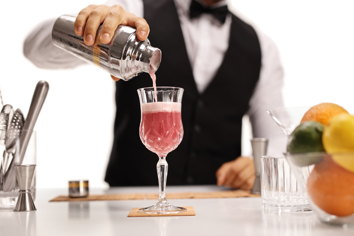 Bartender pouring his signature cocktail in a glass
