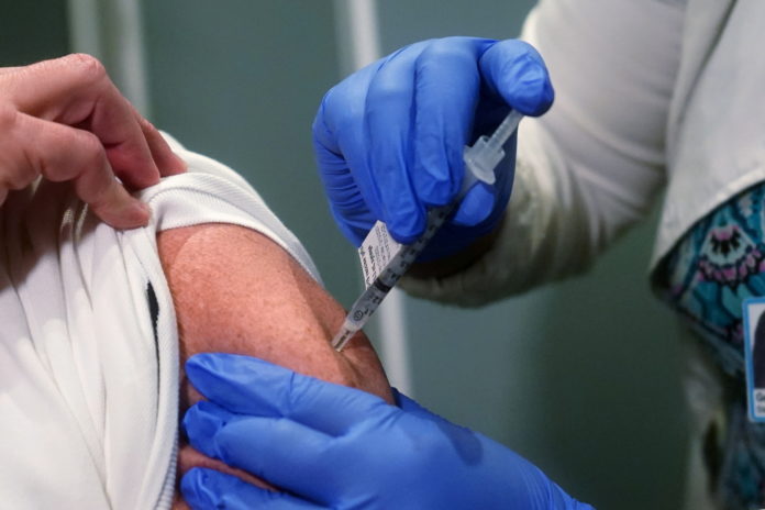 FILE PHOTO: A nurse receives one of the first vaccinations at Mt. Sinai Hospital from Pfizer-BioNTech, in New York national guard