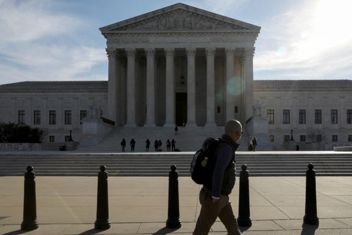FILE PHOTO: Pedestrian walks by the U.S. Supreme Court building in Washington roe v wade