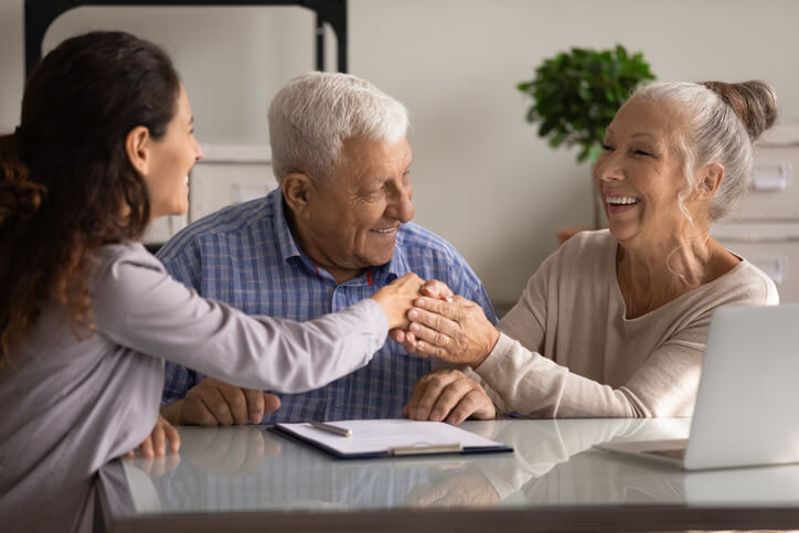 Happy senior couple of clients meeting with real estate agent