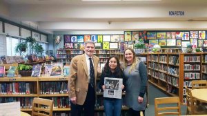 Rika Mizoguchi is congratulated by Principal James Kassebaum and her ELA teacher Anne O’Toole for winning the Long Island Regional Spelling Bee.