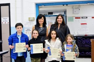 Students, Principal Joanne Mannion and PTA committee chairperson Jeanine Berliner at the March PTA meeting’s special ceremony for Reflections participants.