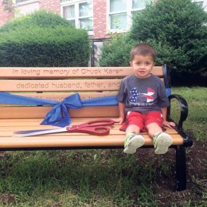 Anthony Pisani sits on the bench dedicated to the memory of his uncle, Charles “Chuck” Karen.