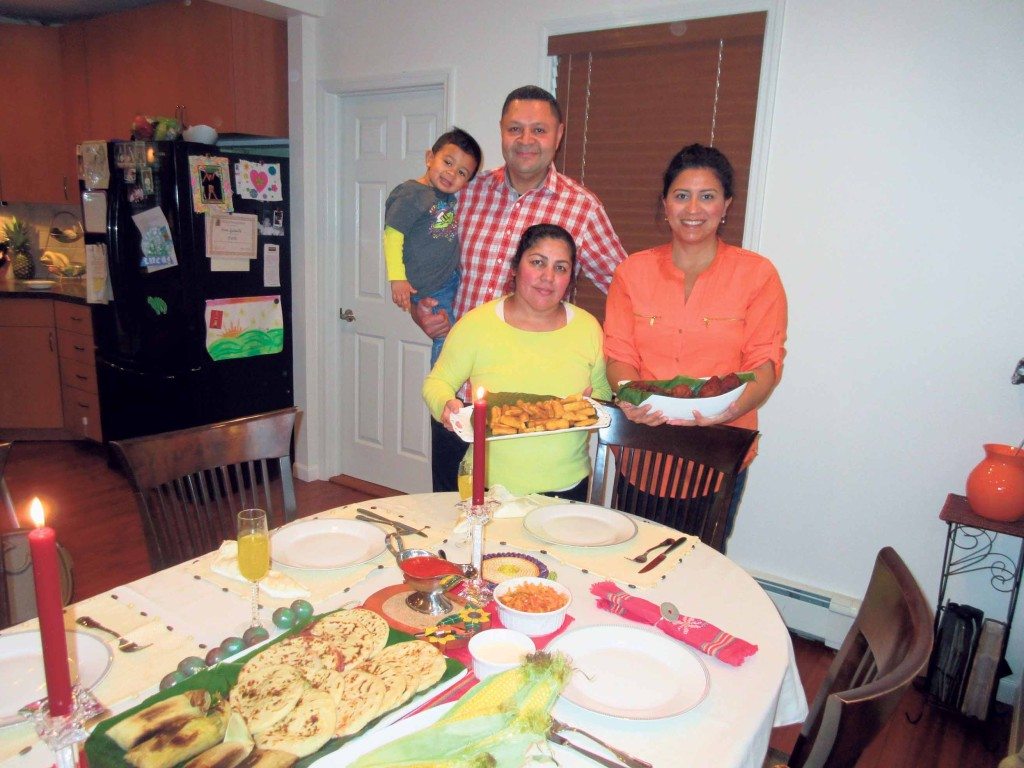 The Quintanillas with Senei Posada. Senei is holding yucca, Sasha is holding empanadas and Pedro is holding Lucas.