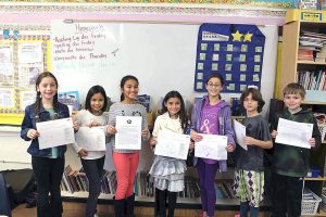 Fourth-graders in Kaitlin Zara’s class “flaunt” their essays in which they proudly wrote about the things that make them unique.