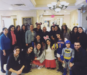Elnaz Ramezani, volunteer; David Sterling, assistant director of Therapeutic Recreation; community members; and children celebrate Purim.