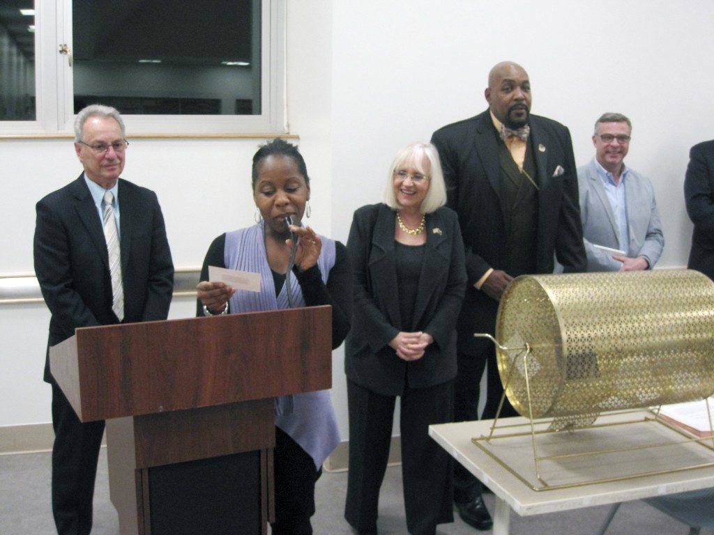 Councilwoman Viviana Russell reads the name of a lotto winner