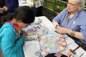 Co-recording secretary Maureen Baranov helps attendees create beautiful paper flower pins 