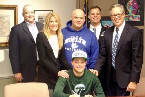 Pictured standing behind Jeremy Kaplan are Roslyn High School Principal Andrew Scott, Jeremy’s mother Elayna Kaplan, Michael Corcoran, Athletic Director Peter Melore, and Jeremy’s father, David Kaplan.