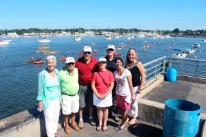 Vera Allen (center), at 85, the senior paddler, posing with Edna Turner, founder of North Shore Kayak Club, and Joel Ziev, cochair of Kayak Run and Community Chest board member, in front of the first place prize—a brand new kayak