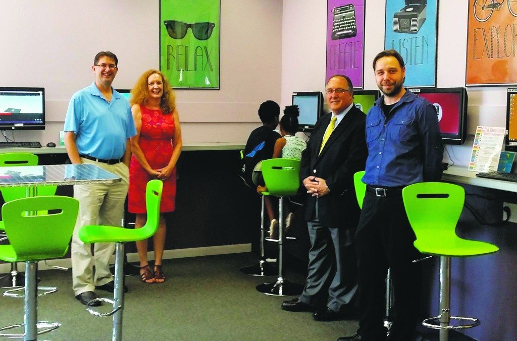 Library Board of Trustees President Eric Dobrin, LIbrary Director Cathleen Merenda, Assemblyman Michael Montesano and Head of Technology James Hutter in the library's new teen zone