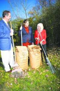 From right: Supervisor Judi Bosworth rakes up some leaves and places them in the new biodegradable paper bags with Chief Sustainability Officer Erin Reilley and Solid Waste Management Authority Executive Director Igor Sikiric.