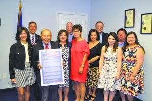 Jack Martins (second from left) congratulates Dr. Lewis Licht (third from left) on his induction into the New York State Senate's Veterans' Hall of Fame. They are joined by members of Licht's family. 
