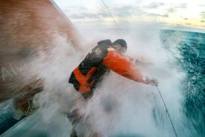 November 06, 2014. Leg 1 onboard Team Alvimedica. Day 26. The final 100 miles of Leg 1 prove to be the hardest on the heavy-air sprint into Cape Town. Seb Marsset takes a wave to the chest during a sunset sail change.