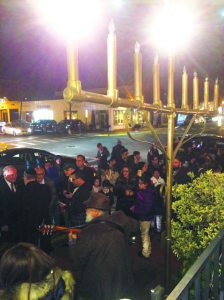 The community gathered to light the second Hanukkah candle on the menorah dedicated by Salomon Nehmad in loving memory of his mother, Fortuna Cabani Nehmad.