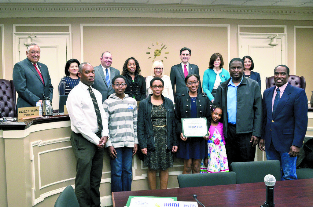 Denisha West (front row, center) was recently honored by the Town of North Hempstead board. Pictured are (front row, from left) Westbury High School Track and Field Coach Darwin Harrison, Andrew West, Denise West, Denisha West, Sasha West, Eric West, Westbury High School Track and Field Coach Donald R. Ross. (Back row, from left) Councilmembers Angelo Ferraro, Anna Kaplan, Peter Zuckerman, Viviana Russell, Supervisor Judi Bosworth, Town Clerk Wayne Wink and Councilmembers Lee Seeman and Dina De Giorgio.