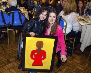 Mariah, a senior at Henry Viscardi School at The Viscardi Center, presenting the painting of Chilina she created, with Chilina