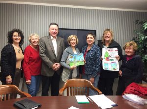 Manhasset Chamber of Commerce board members Suzanne Sokoloff, Katie Miller, CJ Coleman, Nancy Morris, Marion Stainkamp, Elizabeth Johnson and Diane Harragan holding up poster entries. Photo by Pat Grace